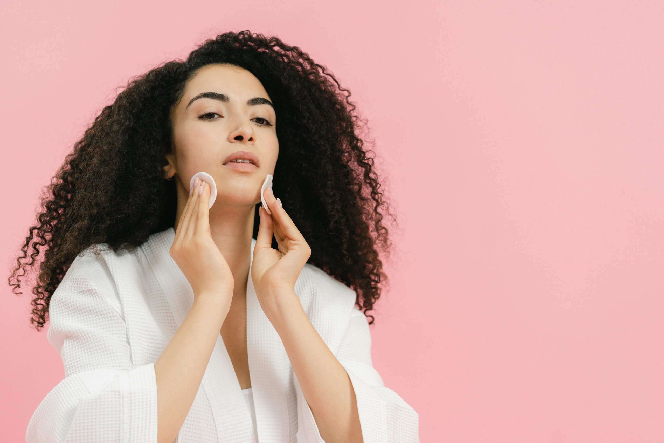 woman applying skincare to her face 